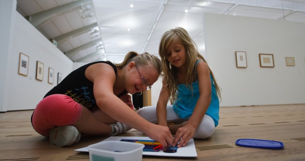 Zwei Kinder mit und ohne Behinderung malen auf dem Boden der Ausstellungsräume im Zentrum Paul Klee. 