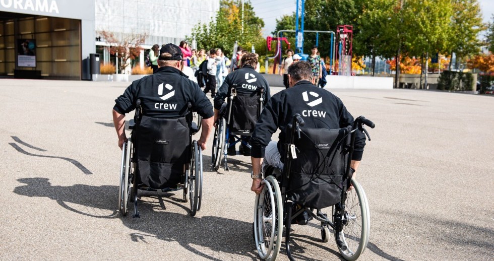 Drei Mitarbeitende des Technoramas fahren in Rollstühlen über den Vorplatz des Technoramas im Rahmen der Sensibilisierung für Menschen mit körperlicher Behinderung.